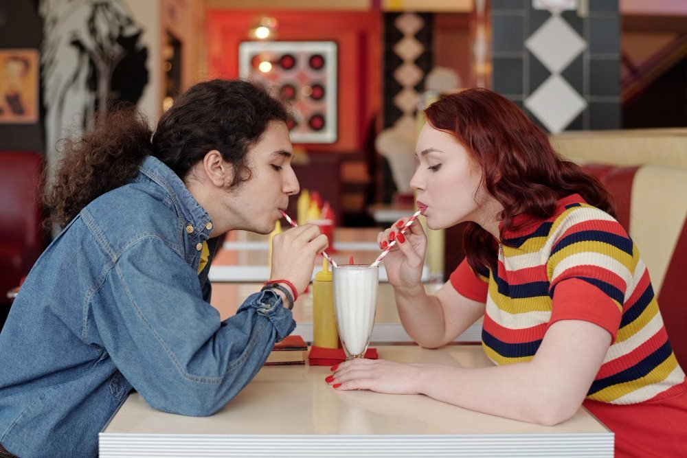 A couple sharing a playful date at a diner